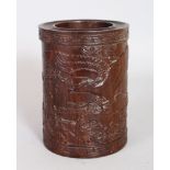 A CHINESE CARVED ROSEWOOD BRUSHPOT, carved with an eagle on a mountainous landscape. 6ins high.