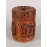 A CHINESE CARVED CIRCULAR BAMBOO BOX AND COVER, carved with four panels. 6.5ins high.