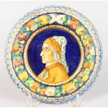 A GOOD ITALIAN FAIENCE CIRCULAR PORTRAIT PLAQUE, the colourful border with fruit. 7ins diameter.