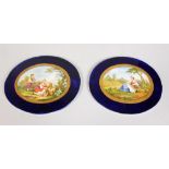 A PAIR OF OVAL PORCELAIN PANELS, rich blue borders, the centre painted with a shepherdess and sheep,