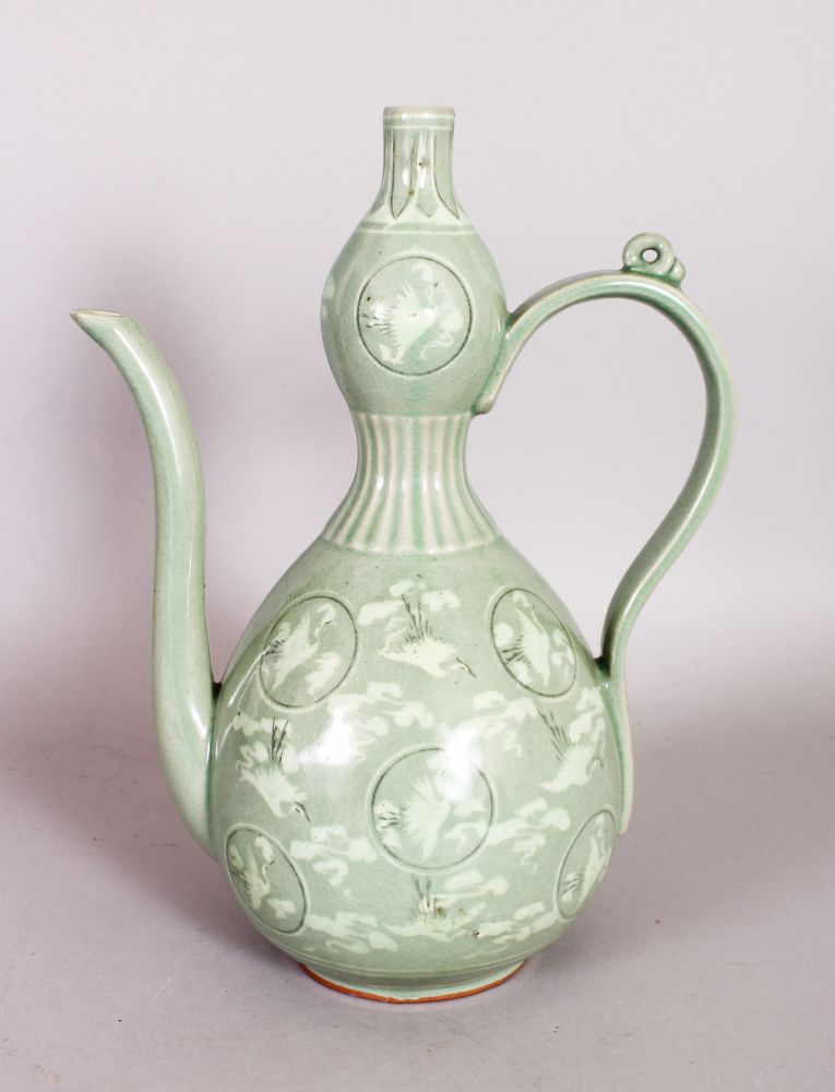 A GREEN EWER decorated with storks in circular panels. 12ins high.