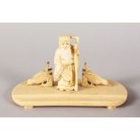 A CHINESE IVORY PEN REST, an old man with two birds. 7ins long.