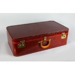 AN EMBOSSED LEATHER SUITCASE, BY CAVANAUGH, complete with outer canvas all-weather cover. 2ft 5ins