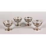 A SET OF FOUR CONTINENTAL SILVER PEDESTAL SALTS, with clear glass liners.