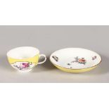 AN 18TH CENTURY MEISSEN RARE YELLOW GROUND TEACUP AND SAUCER with arabesque reserves painted with