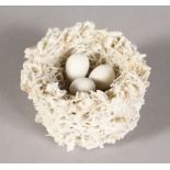 A BRISTOL PORCELAIN BIRD'S NEST containing three eggs.