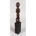 A CARVED SEATED TRIBAL FIGURE. 9ins high.