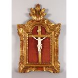 A SUPERB CARVED IVORY CORPUS, 6ins long, in a giltwood cross and Italian giltwood frame.