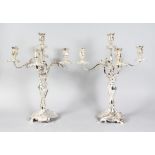A GOOD PAIR OF PLATED FIVE LIGHT CANDELABRA with centre holder and four scrolling arms with acanthus