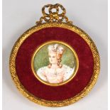 A CIRCULAR MINIATURE OF A LADY WITH FEATHERS IN HER HAIR. Signed. 1.5ins diameter, in a gilt metal