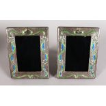 A PAIR OF ART NOUVEAU STYLE SILVER AND ENAMEL PHOTOGRAPH FRAMES. 7.75ins high x 6ins wide.