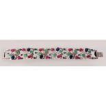 A WIDE SILVER, EMERALD, RUBY AND SAPPHIRE BRACELET.