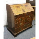 A GEORGE II WALNUT BUREAU, the fall flap enclosing numerous drawers, pigeonholes and a well, above