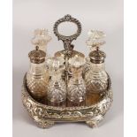 A GEORGE IV SEVEN BOTTLE CRUET with gadrooned handle and repousse body, on four shell feet with