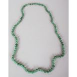 A CHINESE JADE-LIKE HARDSTONE NECKLACE, composed of spherical beads divided by smaller gilt-metal