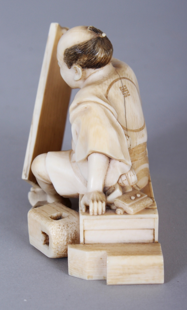 A GOOD QUALITY SIGNED JAPANESE MEIJI PERIOD IVORY OKIMONO OF SEATED CARPENTER, holding between his - Image 4 of 6