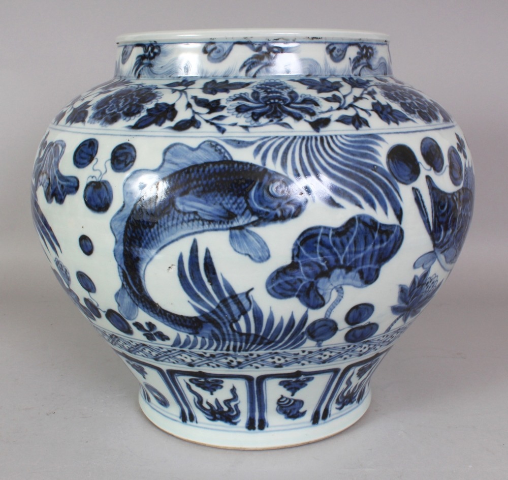 A LARGE CHINESE YUAN STYLE BLUE & WHITE PORCELAIN CARP JAR, the base unglazed, 13.25in wide at