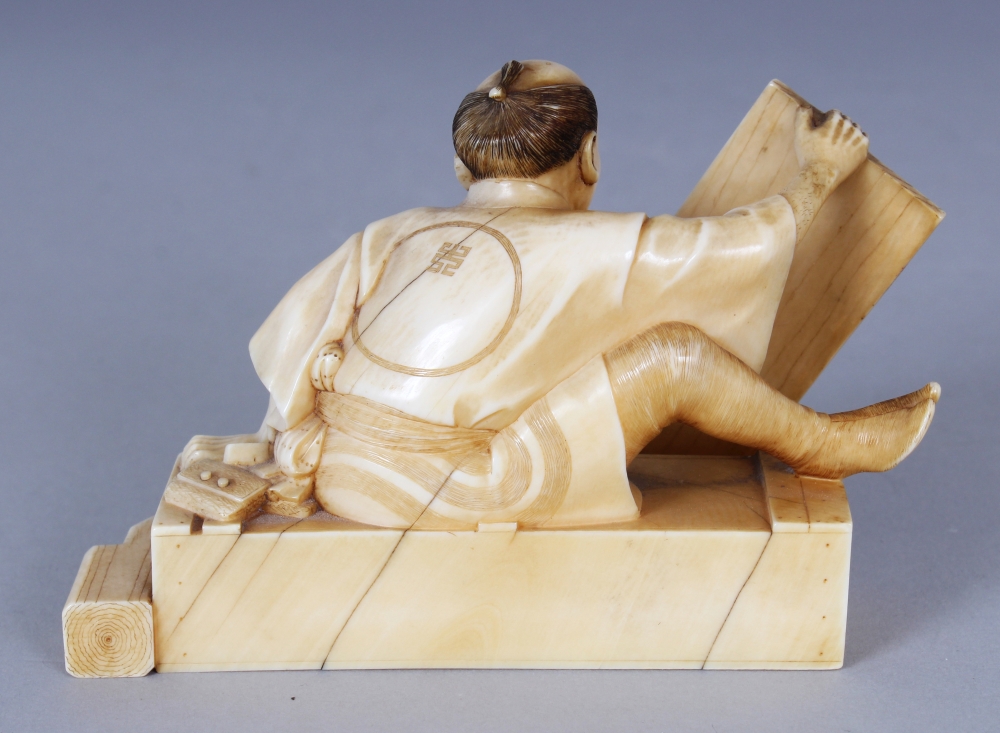 A GOOD QUALITY SIGNED JAPANESE MEIJI PERIOD IVORY OKIMONO OF SEATED CARPENTER, holding between his - Image 3 of 6