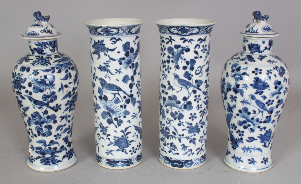 A GARNITURE OF FOUR 19TH CENTURY CHINESE BLUE & WHITE PORCELAIN VASES, two with covers, each painted