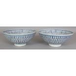 A NEAR PAIR OF CHINESE BLUE & WHITE PROVINCIAL STYLE PORCELAIN SHOU BOWLS, each decorated to its