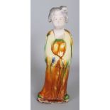 A CHINESE TANG STYLE GLAZED POTTERY FIGURE OF A STANDING FEMALE ATTENDANT, the base unglazed, 11.