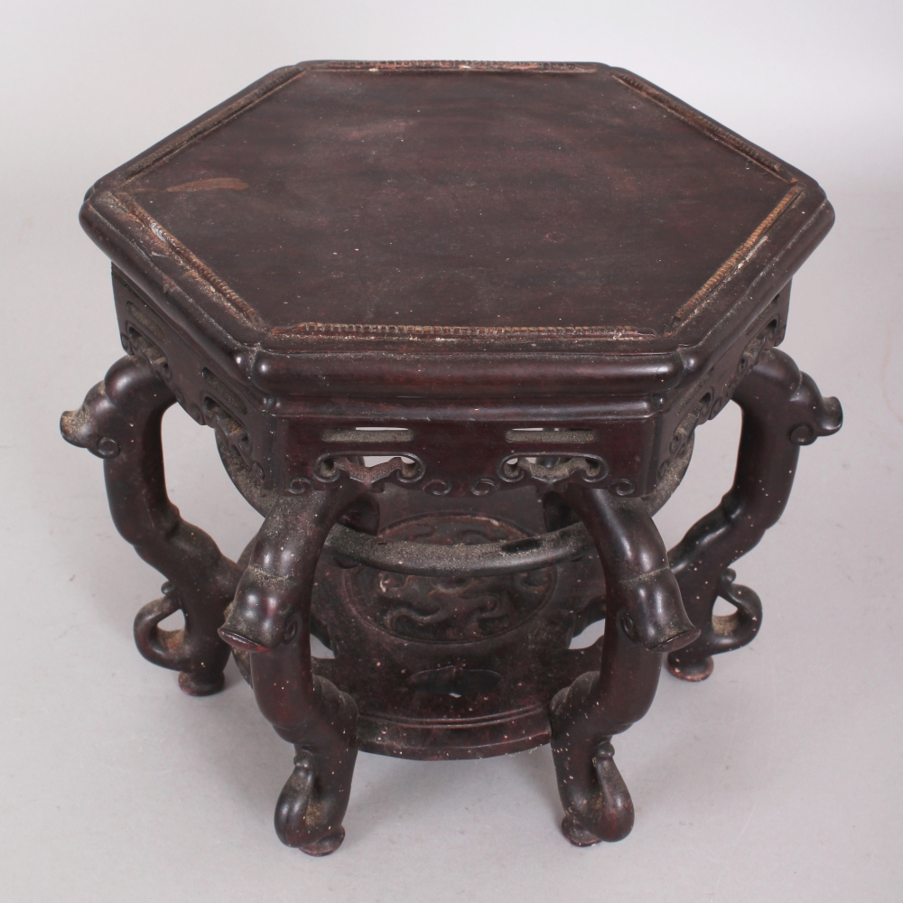 A GOOD QUALITY CHINESE HEXAGONAL SECTION CARVED HARDWOOD STAND, with pierced frieze and undertier,