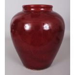 A CHINESE COPPER RED OVOID PORCELAIN VASE, applied with a mottled glaze, the base with a celadon