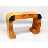 AN ART DECO STYLE BURR WOOD CONSOL TABLE, with a small drawer on curving end support 4ft 0in wide