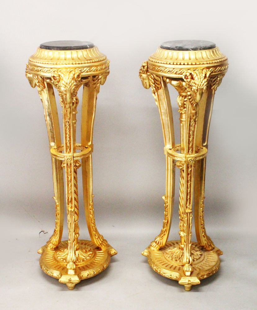 A PAIR OF GILT WOOD TORCHERES, with marble tops and rams head decoration, 3ft 10in high