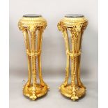 A PAIR OF GILT WOOD TORCHERES, with marble tops and rams head decoration, 3ft 10in high