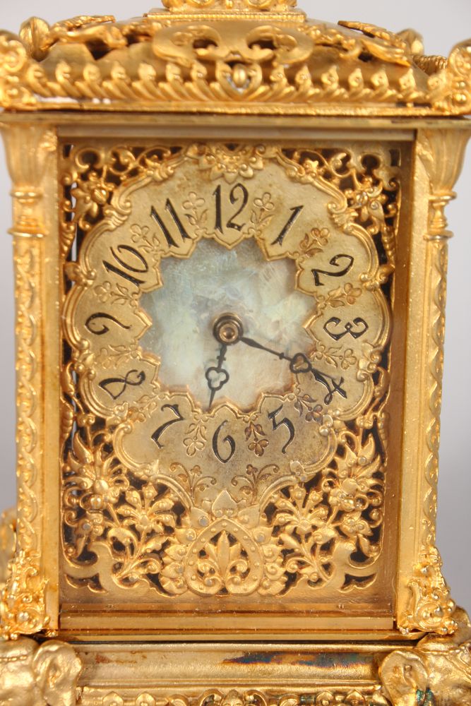 AN ORMOLU CARRIAGE CLOCK, with ornate pierced dial and case, on elephant head feet 7in high - Image 2 of 3