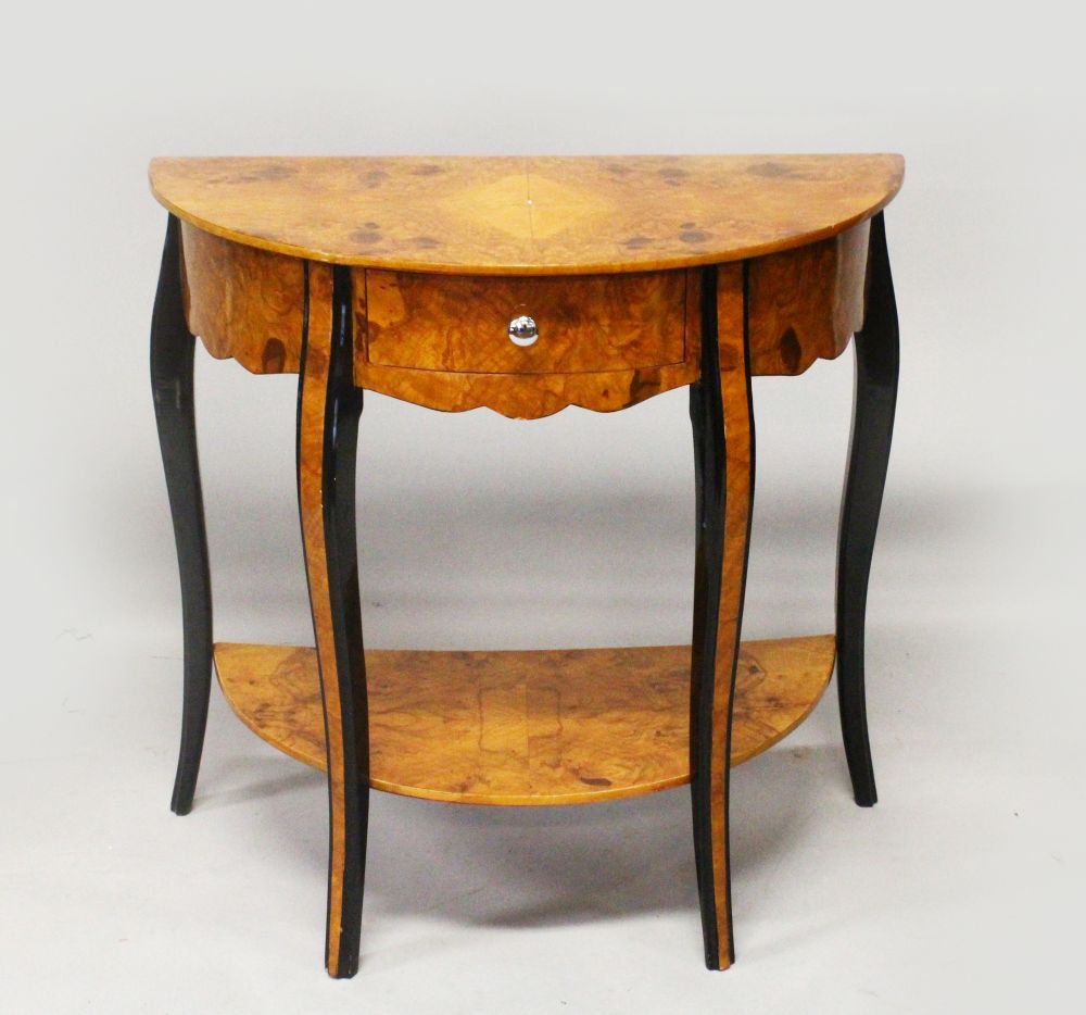 AN ART DECO STYLE BURR WOOD DEMI-LUNE CONSOLE TABLE, with a single drawer on curving legs united