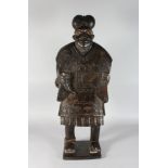 AN UNUSUAL CARVED WOOD STANDING FIGURE, POSSIBLY MAORI, with open body and carrying a horn 3ft 6in