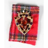 A SCOTTISH SHIELD SHAPE BROOCH, set with coloured stones