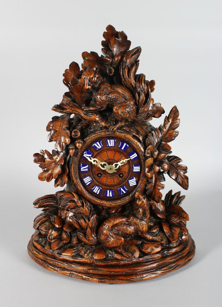 A GOOD 19TH CENTURY BLACK FOREST CARVED WOOD CLOCK, with blue and white Roman numerals, 8 day