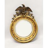 A 19TH CENTURY GILT FRAMED CONVEX MIRROR, with carved eagle cresting, ball finial applied frame. 2ft