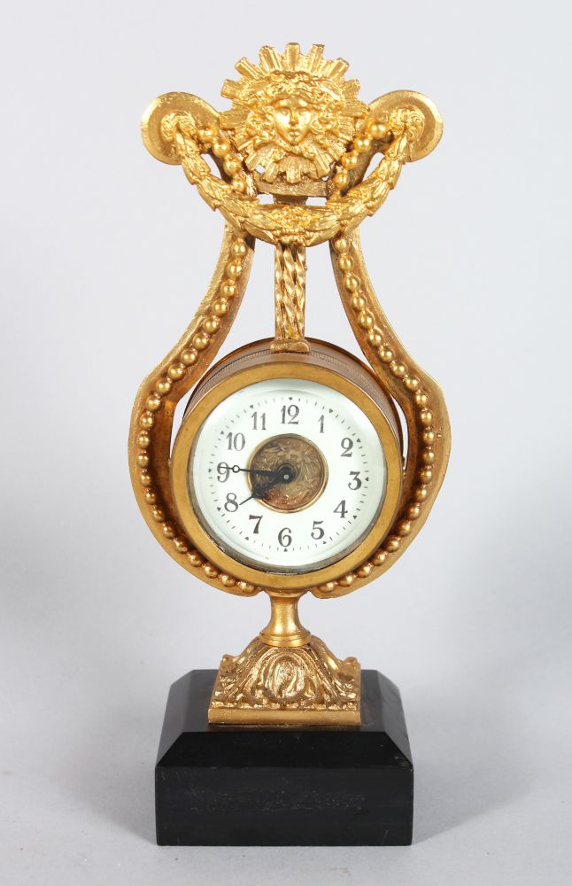 A SMALL GILDED LYRE CLOCK, on a marble base, 8.5in high