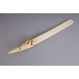 A GOOD QUALITY JAPANESE MEIJI PERIOD IVORY PAGE TURNER, the handle well carved in relief with two