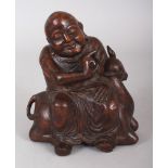 A 19TH CENTURY CHINESE CARVED BAMBOO FIGURE OF BUDAI, seated on the back of a deer, 5.6in high.