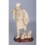 A JAPANESE MEIJI PERIOD SECTIONAL IVORY OKIMONO OF A STANDING FARMER, together with a fixed wood