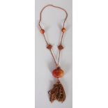 A 20TH CENTURY CHINESE AGATE & CORD NECKLACE, bearing two pierced spherical beads and a pierced