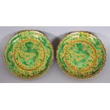 A SMALL PAIR OF CHINESE GREEN & YELLOW GLAZED DRAGON DISHES, with frilled rims, each base with a