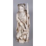 AN EARLY 20TH CENTURY JAPANESE BONE OKIMONO OF A STANDING FEMALE DEITY, holding a flower spray and a