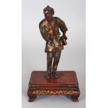 A GOOD QUALITY JAPANESE MEIJI PERIOD MIYAO PARCEL GILT BRONZE OKIMONO OF A STANDING MAN, mounted