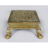 An Indian Brass Overlaid Wood Stool, 19th Century, the embossed surface decorated with formal