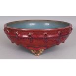 A CHINESE MING STYLE JUN WARE RED & BLUE GLAZED CERAMIC NARCISSUS BOWL, supported on three ruyi