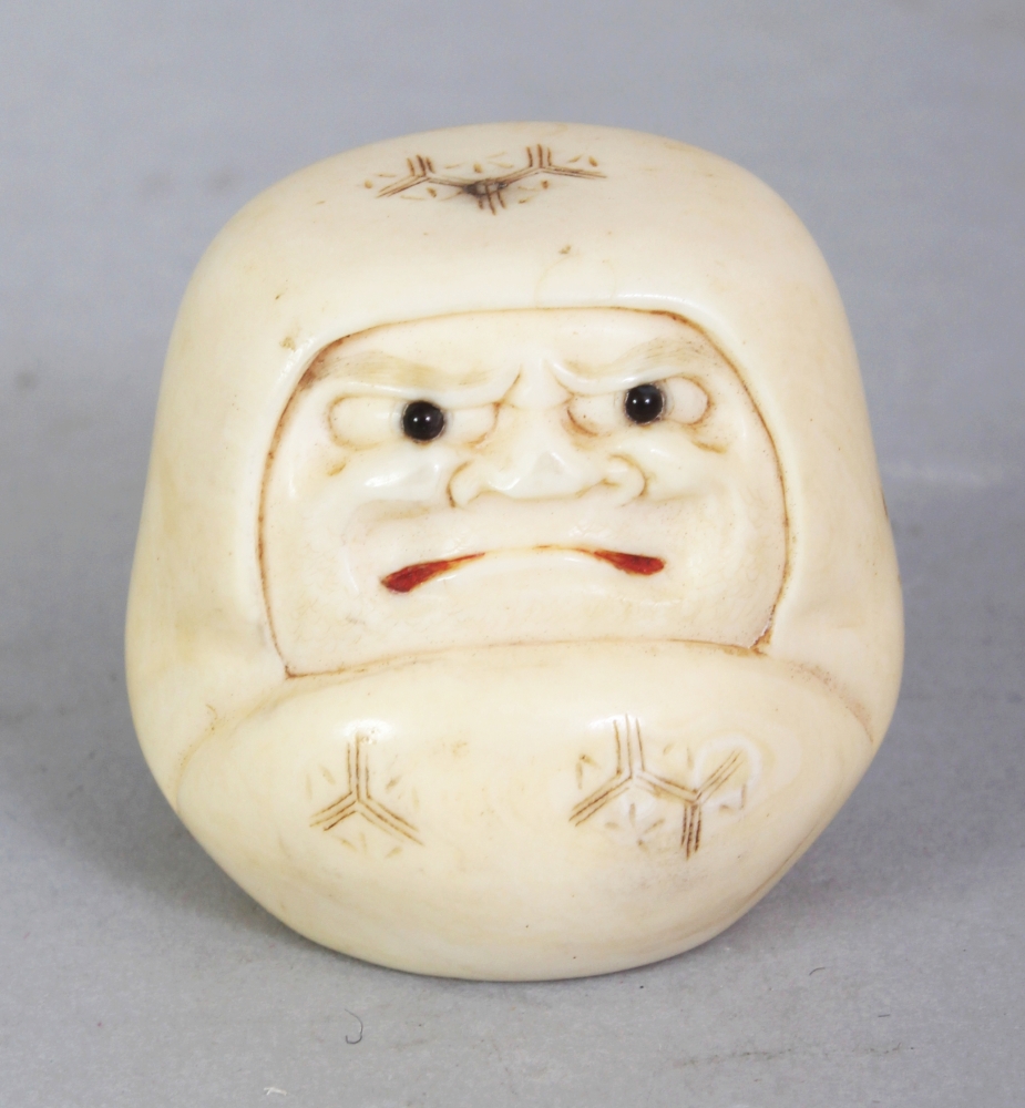 A SIGNED JAPANESE MEIJI PERIOD IVORY NETSUKE OF A DARUMA DOLL, with frowning expression, his mouth