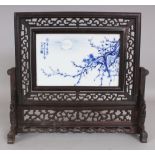 A CHINESE WOOD FRAMED PORCELAIN TABLE SCREEN, fitted with a revolving framed porcelain plaque