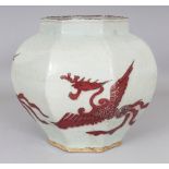 A CHINESE YUAN STYLE COPPER-RED OCTAGONAL SECTION PORCELAIN PHOENIX JAR, the base unglazed, 9.5in