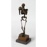 AFTER CARL KAUBA (1865-1922) AUSTRIAN A BRONZE STANDING SKELETON holding a skull. Signed, 12ins